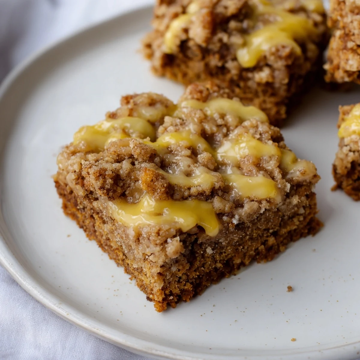 Freshly baked Lemon-Glazed Gingerbread Crumble Bars showcase a perfect mix of textures and tantalizing spiced aromas.