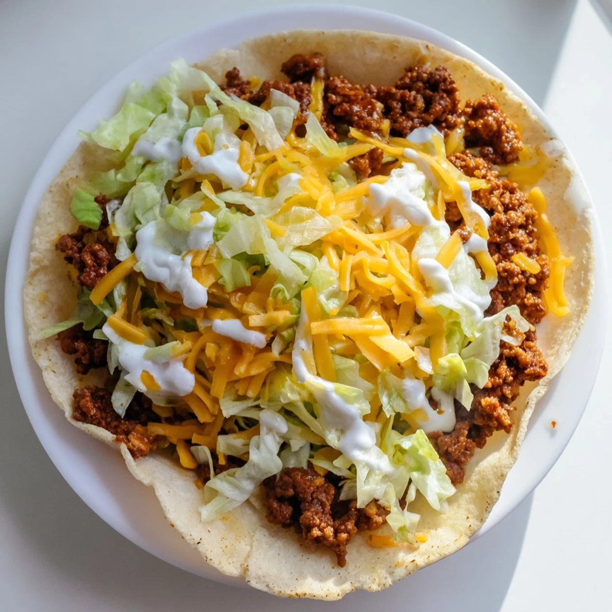 A close-up of a Cheesy Gordita Crunch taco shows a perfect bite, complete with beef, cheese, and sauce.