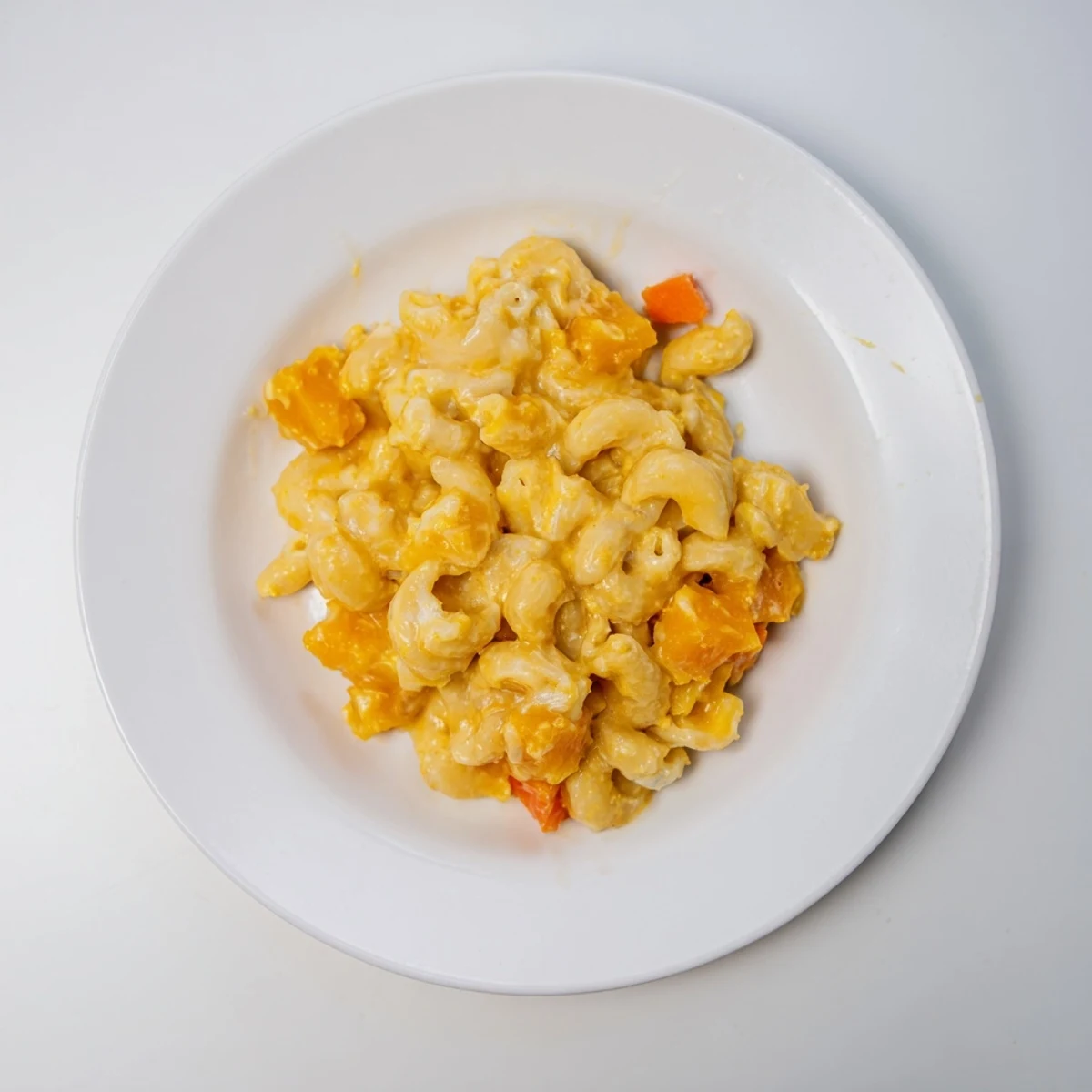 A steaming bowl of vibrant One-Pot Butternut Squash Mac & Cheese, cheesy and creamy.