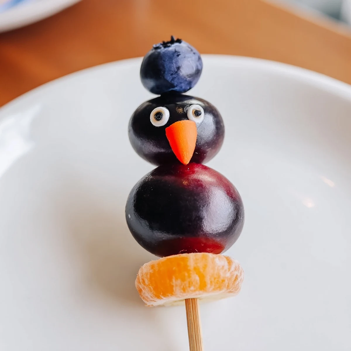 Colorful Penguin Fruit Skewer Army featuring strawberries, grapes, and oranges, perfect for kid-friendly snacks.
