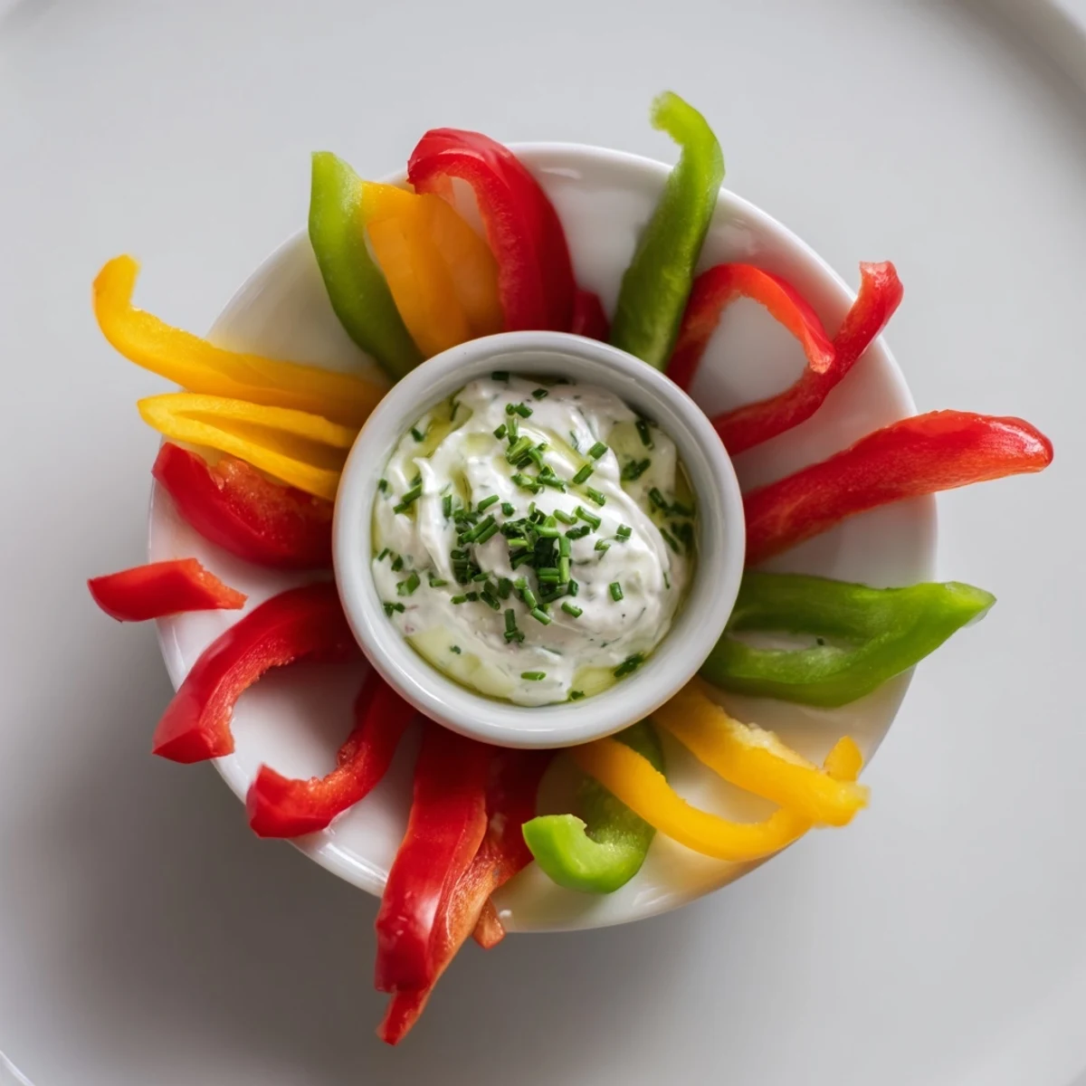 Crisp bell pepper strips arranged for a nutritious snack, served alongside seasoned Greek yogurt.