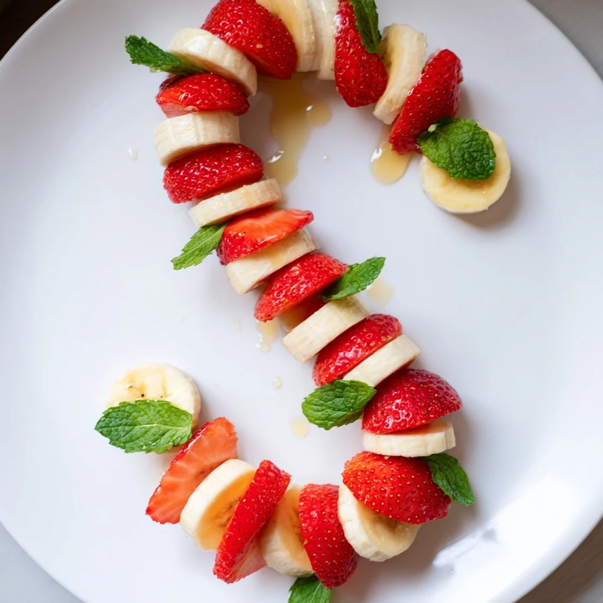 Freshly sliced Banana Strawberry Candy Cane: a festive, colorful snack arranged in a candy cane design.