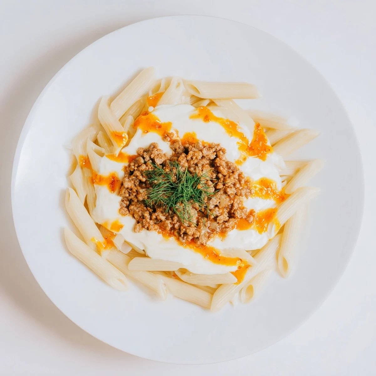 A steaming bowl of Turkish Pasta with Ground Turkey, garnished with fresh herbs, is ready to savor.