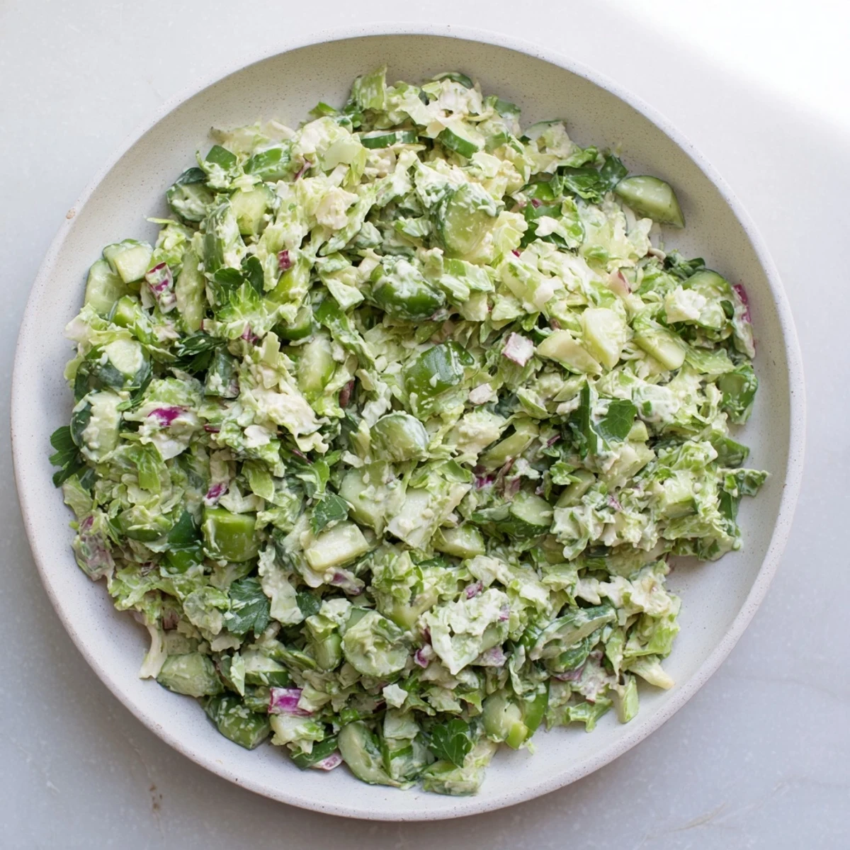 This Green Goddess Cabbage Dip showcases a colorful, chopped salad swirled in creamy dressing and ready to serve.