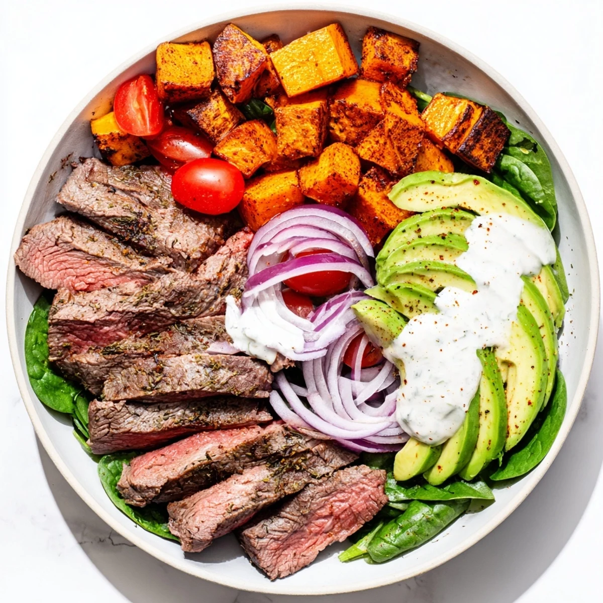 Tender beef avocado sweet potato bowl with vibrant colors and a creamy yogurt dressing awaiting savoring.