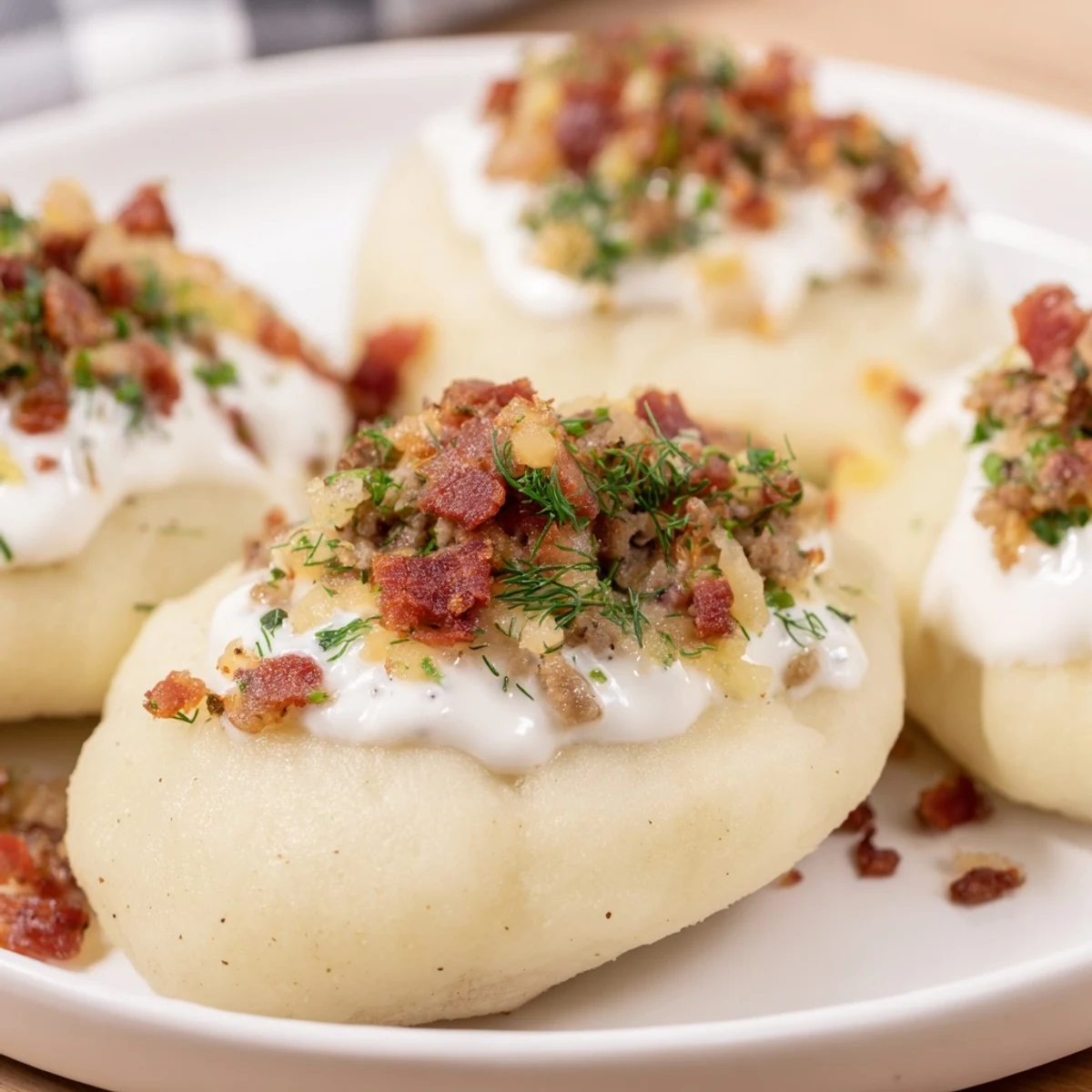 Steaming hot Lithuanian Cepelinai dumplings with savory pork filling, ready to serve with sauce.