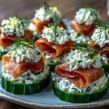Elegant appetizer platter featuring smoked salmon cucumber bites with fresh dill garnish.  