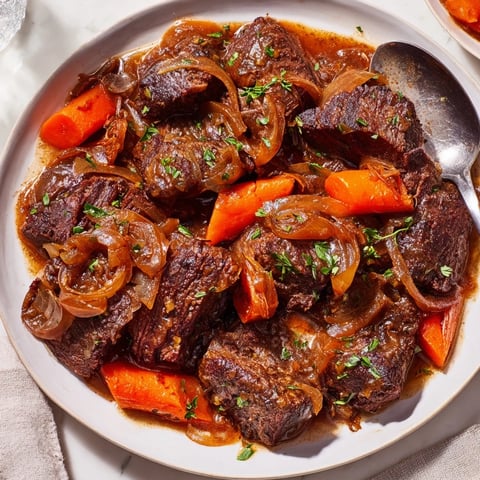 Tender braised beef with caramelized onion gravy served over creamy mashed potatoes.  