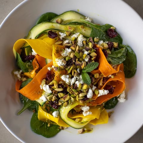 Vibrant ribbons of fresh vegetables with crunchy pistachios and cranberries in the Pistachio Cranberry Layered Salad.