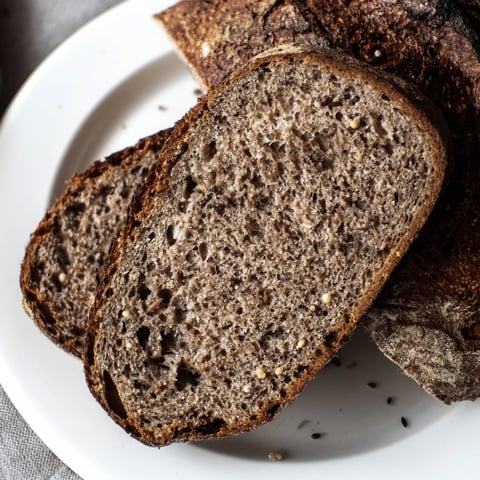 Freshly baked Estonian Leib sourdough loaf, crusty and dark, ready to slice.