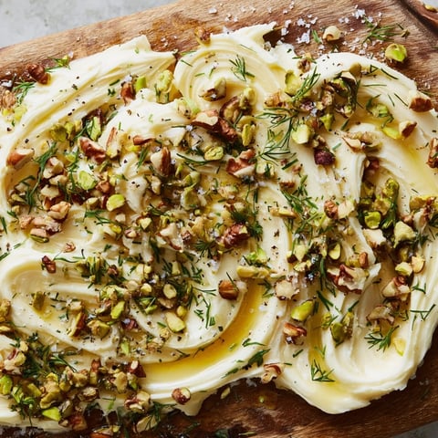 A creamy Flavored Butter Board spread with chopped nuts, herbs, and honey drizzle for entertaining.  