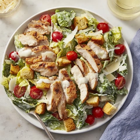 Vibrant grilled chicken strips top crisp romaine, cherry tomatoes, and croutons in this light Yogurt Caesar Grilled Chicken Salad.