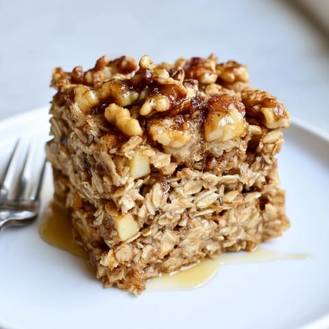 Golden-brown Maple Walnut Baked Oatmeal topped with crunchy walnuts and fresh fruit slices.  