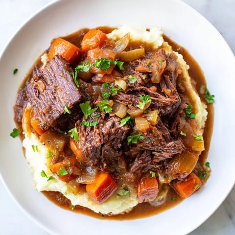 Close-up of a steaming slow cooker pot roast with rich, flavorful gravy and vegetables.