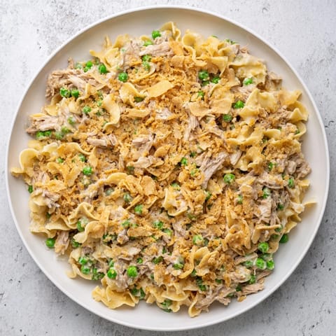 A bubbling baking dish of Creamy Tuna Noodle Casserole, showcasing a classic comfort food meal.