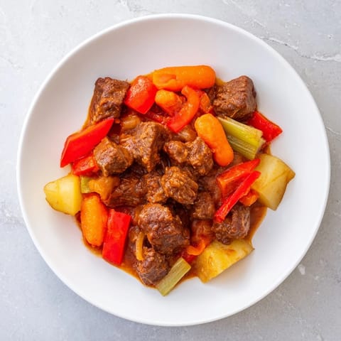 Tender beef cubes swimming in rich, flavorful Smoked Paprika & Garlic Beef Stew, garnished with herbs.
