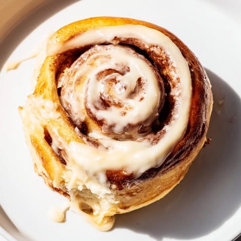 Warm Pillow Soft Cinnamon Rolls fresh from the oven, topped with rich glaze and paired with a steaming cup of coffee.