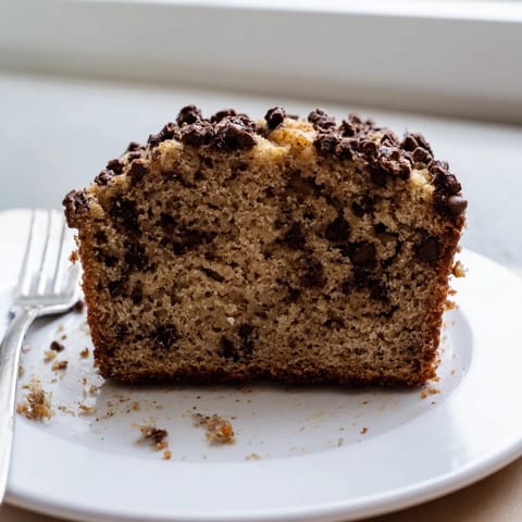 Golden loaf of banana bread with crunchy walnuts, cut to show the tender, moist interior.