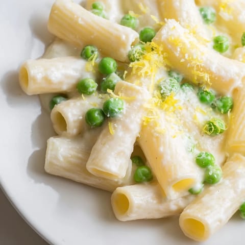 Serving suggestion of Pea & Lemon Ricotta Pasta in a rustic bowl, topped with extra Parmesan and lemon zest.