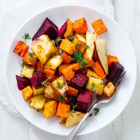 Golden glazed carrots and beets in the roasted root vegetable medley are served warm as a rustic side dish.