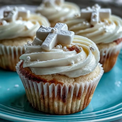 Vanilla cupcakes topped with creamy buttercream and elegant white fondant crosses, ideal for First Communion parties.  