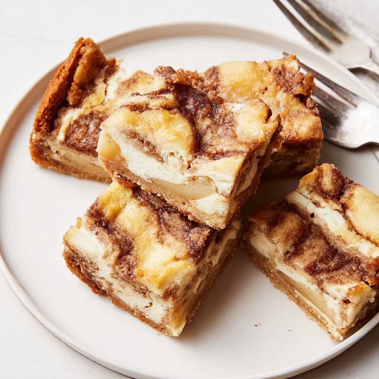 Creamy apple cinnamon swirl bars on a golden crust, tempting and deliciously aromatic.