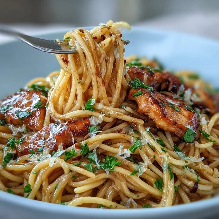 Juicy sliced chicken and al dente spaghetti coated in creamy, sticky honey garlic sauce, ready to serve.