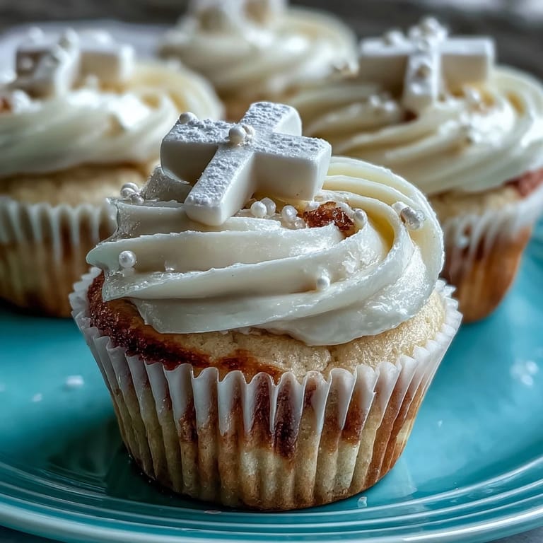 Vanilla cupcakes topped with creamy buttercream and elegant white fondant crosses, ideal for First Communion parties.  