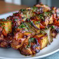 Grilled pineapple chicken skewers with juicy chicken, sweet pineapple, and colorful peppers sizzling on the grill.  