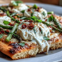 Vibrant roasted asparagus flatbread topped with creamy burrata, fresh lemon zest, and fragrant basil, perfect for spring appetizers.